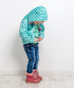 Montessori child doing up jacket